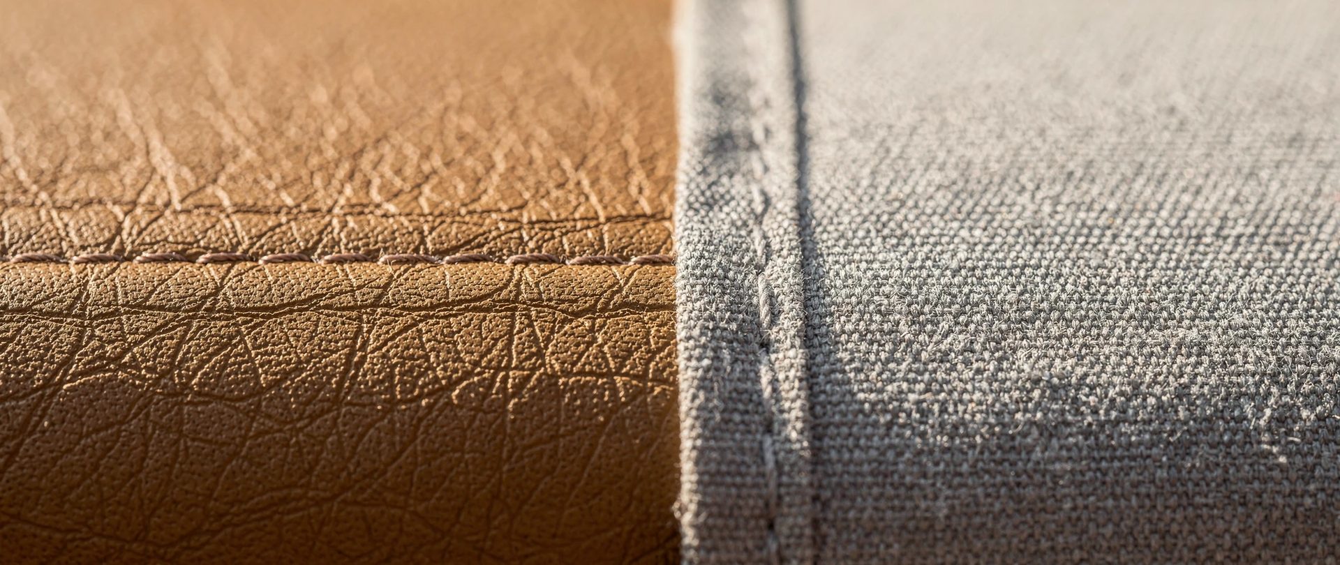 Cuir fauve joint par une couture à une toile marine grise au tissage serré.