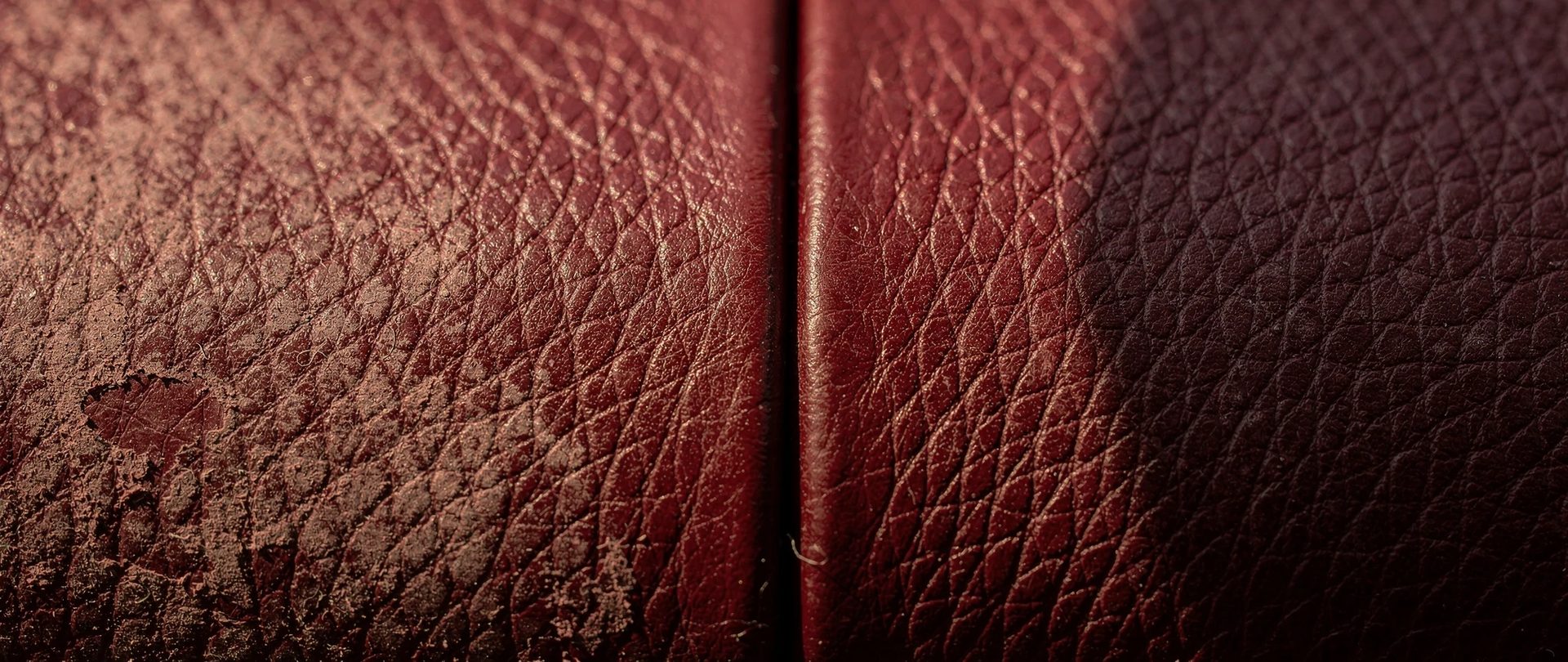 Grain de cuir rouge bordeaux, moitié délavé et usé, moitié fraîchement teint.