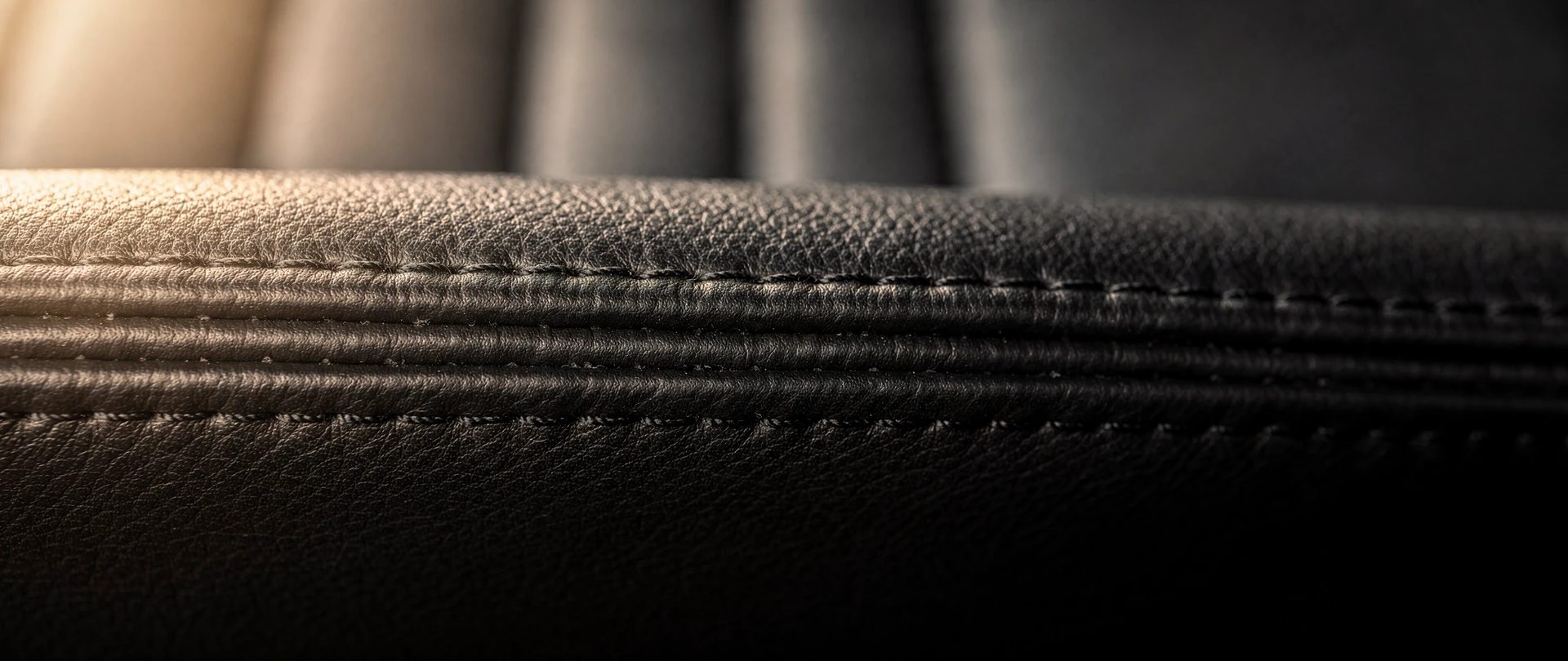Cuir noir d'automobile en rouleaux plissés serrés, avec une double rangée de piqûres.