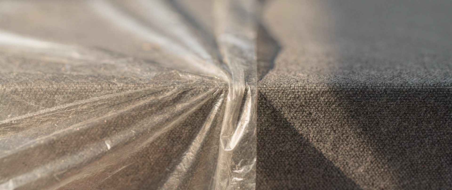 Pellicule transparente tendue et plissée à côté d'une toile grise au tissage épais.