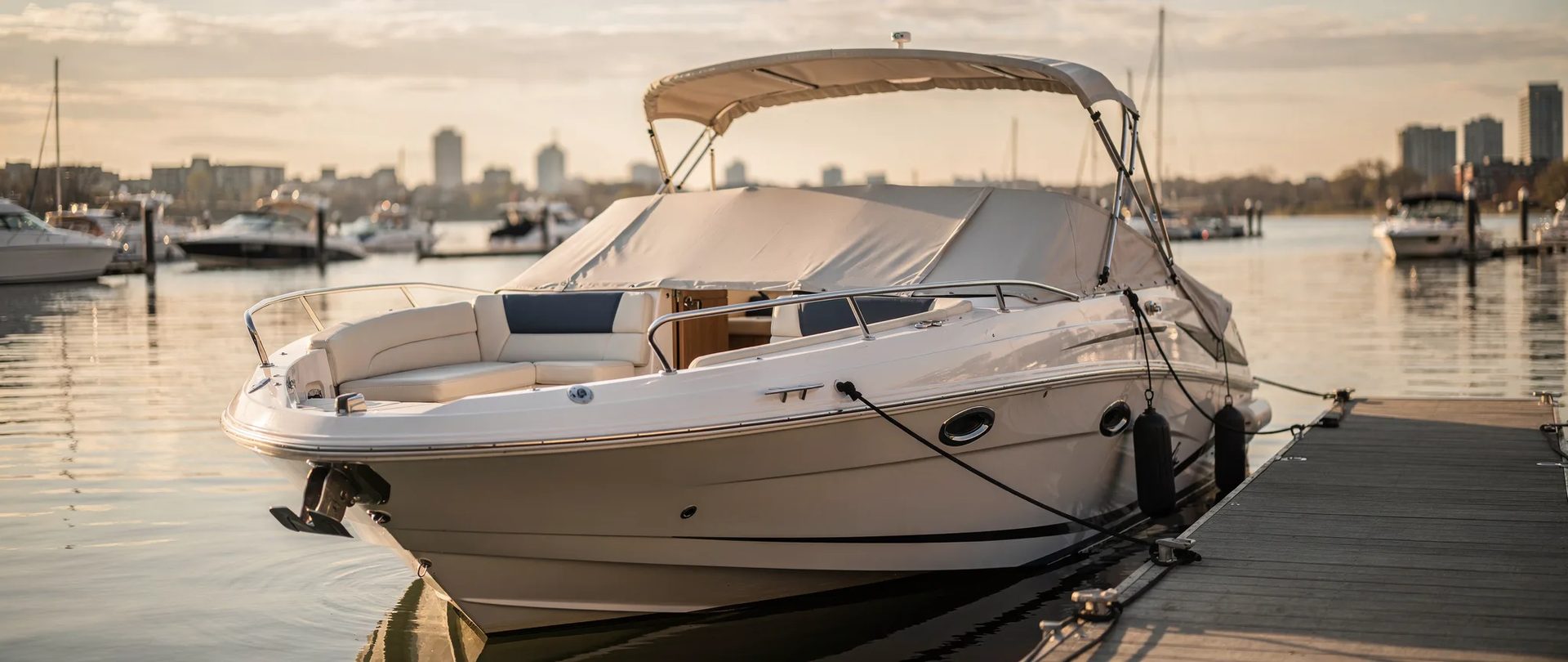 Bateau à proue ouverte à un quai de marina près de Montréal à l'heure dorée, avec coussins et toile en place, pour du rembourrage marin à Montréal.